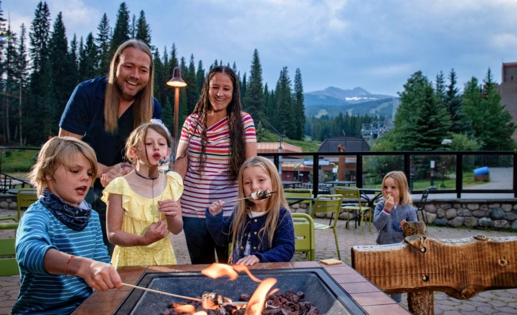family roasting marshmallows at the Beaver Run fireplace