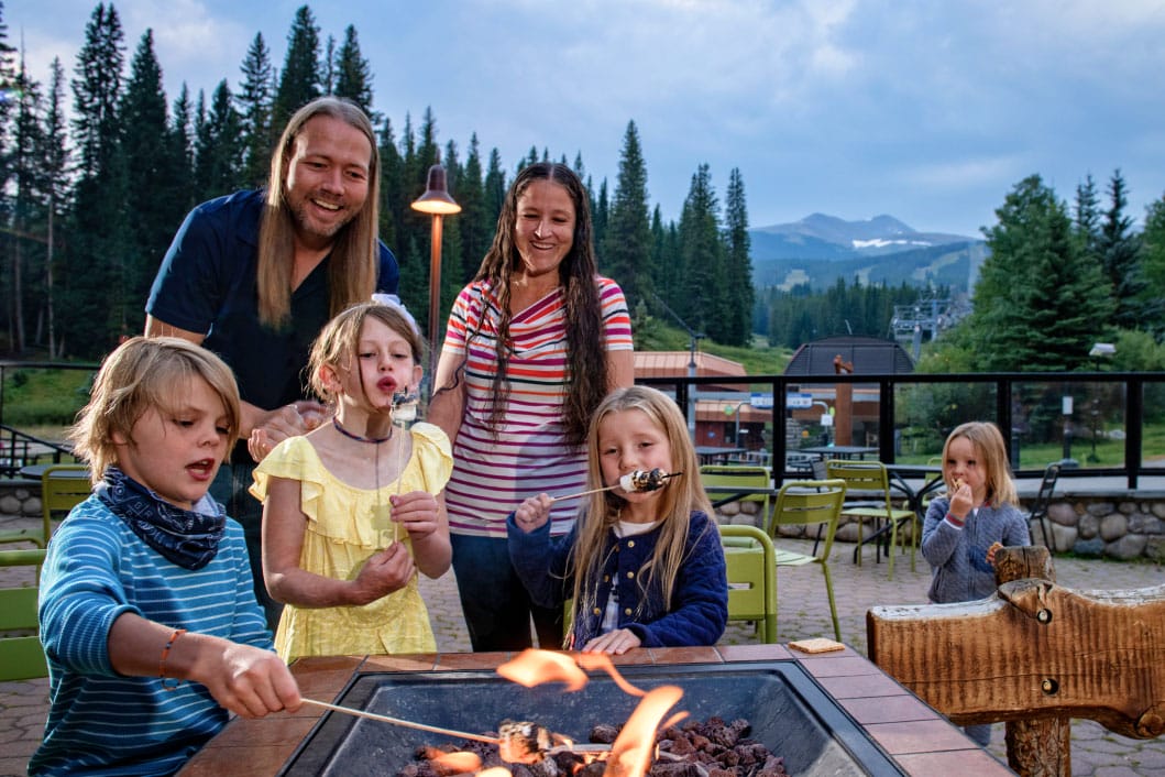 family roasting marshmallows at the Beaver Run Firepit