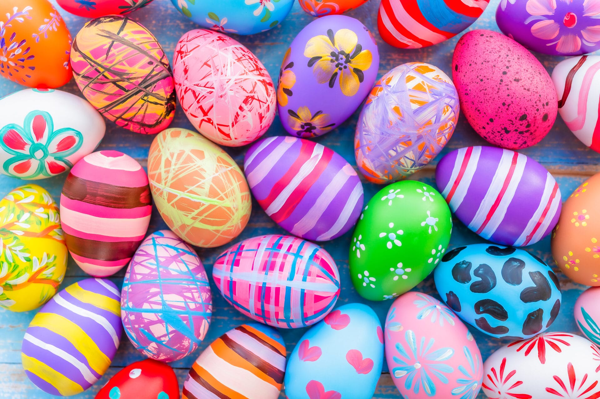Beautiful colorful easter eggs on blue wooden background. Easter holiday concept.