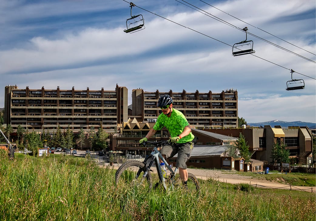 mountain biker riding up the burro trail with Beaver Run in the background
