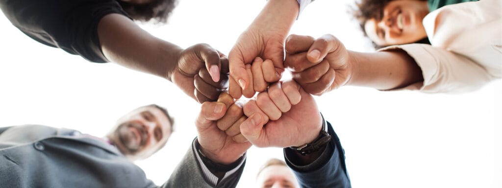 Team building with hands together in a huddle